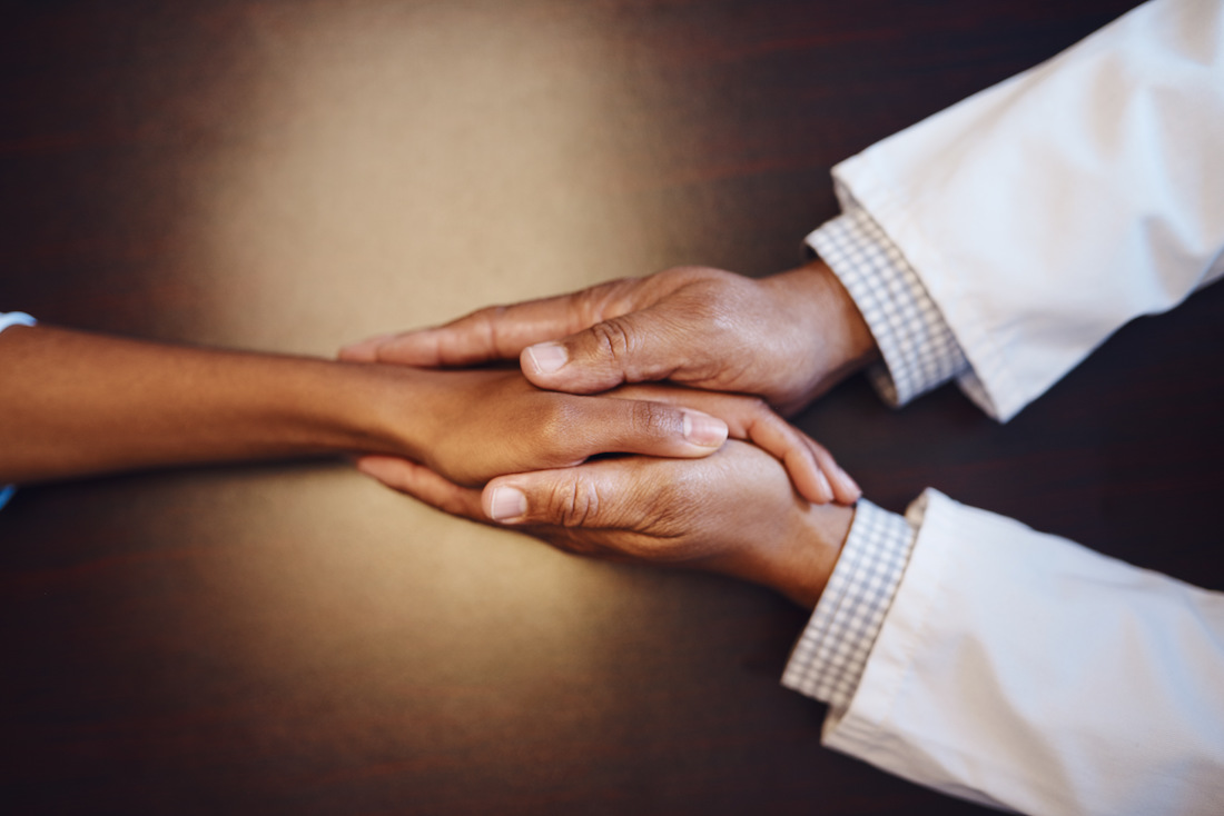 Closeup shot of an man holding another person's hand in comfort.