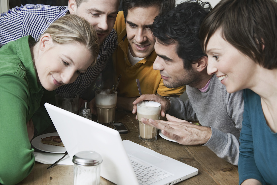 Friends using laptop looking at a website.