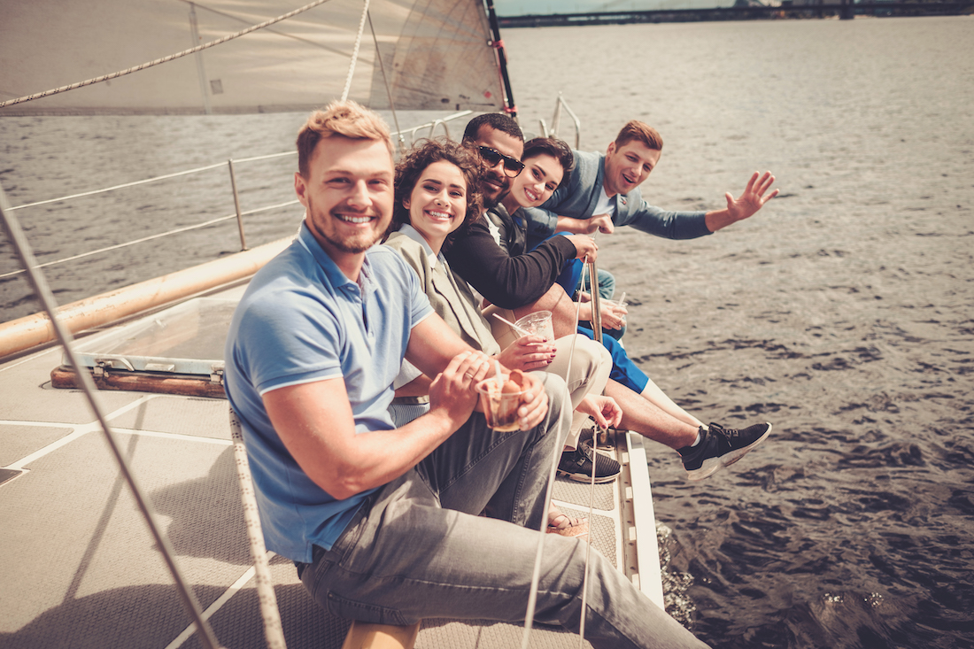 Happy friends enjoying ride on a yacht.